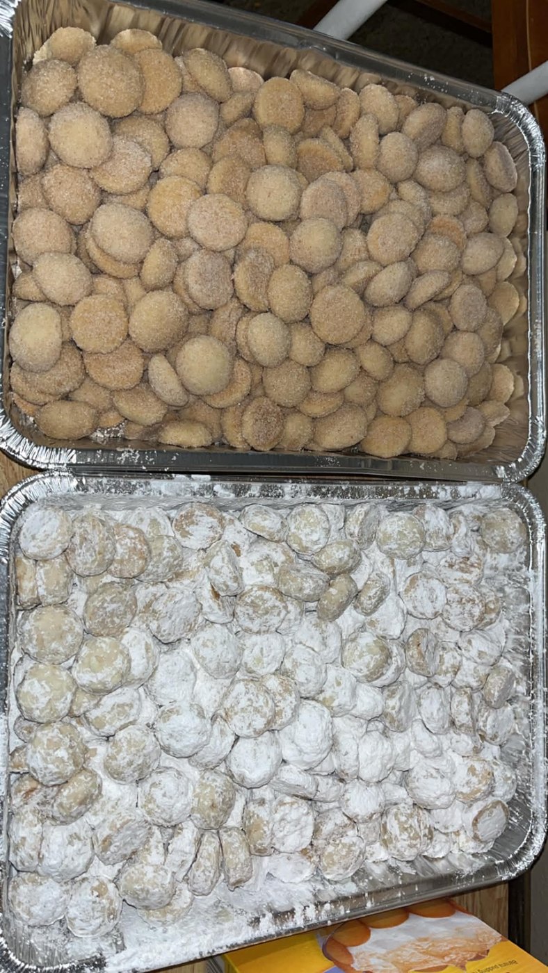 Two pans of bizcochos, cinnamon sugar and powdered sugar